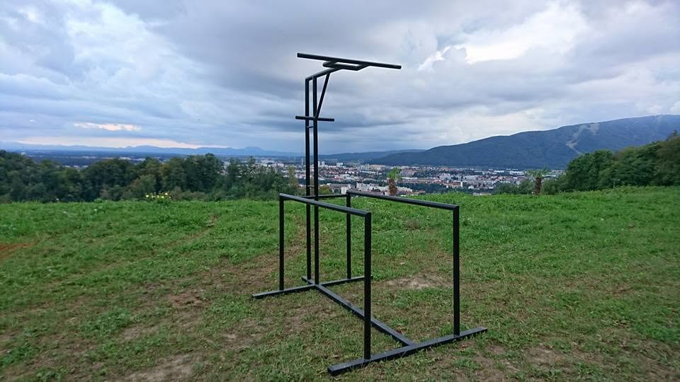 The original GymMachine — the inventor's black steel unit standing on a hilltop overlooking the city